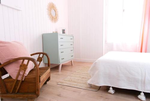 Un dormitorio con una cama, una cómoda y un espejo. en La Mariennée, en La Rochelle