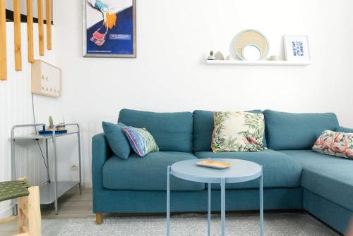 Una sala de estar con un sofá azul y una mesa. en La Mariennée, en La Rochelle
