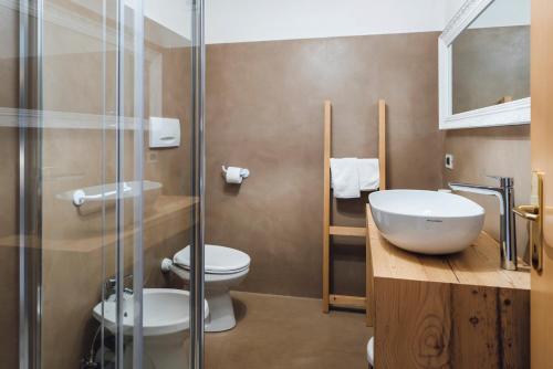 a bathroom with a toilet and a sink and a shower at Ciasa Gianot in Moena