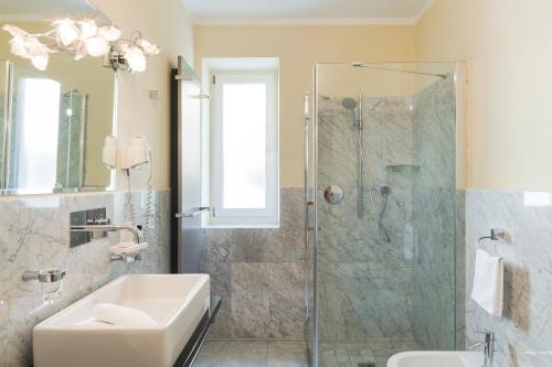 a bathroom with a glass shower and a sink at Hotel Residence Pernhof in Termeno