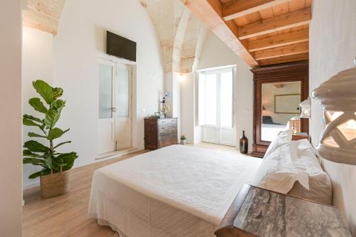 a bedroom with a white bed and a large window at Casa Marugii in Maruggio