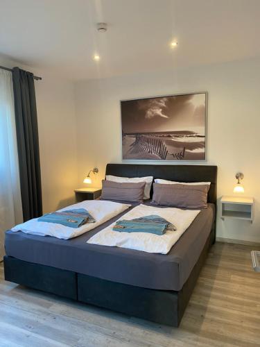ein Schlafzimmer mit einem großen Bett mit zwei Kissen in der Unterkunft Haus Pirola Bensersiel in Bensersiel