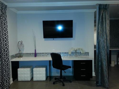 a desk with a chair and a monitor on a wall at Hollywood VIP Hotel in Los Angeles