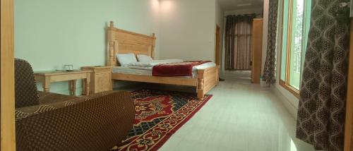 een slaapkamer met een bed, een bank en een tapijt bij Al-Sadiq Hotel & Restaurant Malam Jabba Swat in Swat