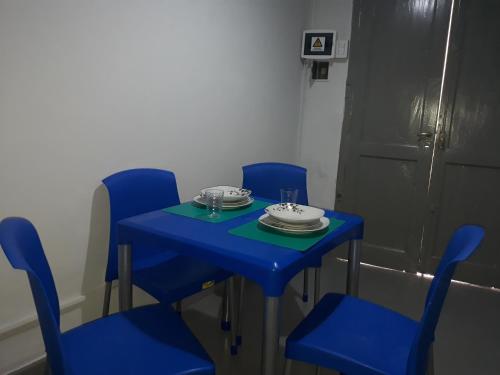 una mesa azul con sillas azules y un plato en ella en Departamentos Santa Fe en Salta
