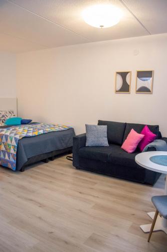 - un salon avec un canapé et un lit dans l'établissement HighHill Lahti City apartment, à Lahti