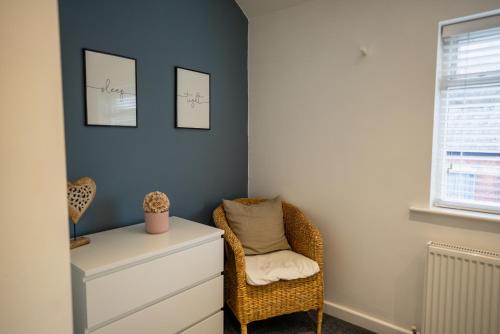 um quarto com uma cadeira, uma cómoda e uma janela em Town Street Apartment em Marple