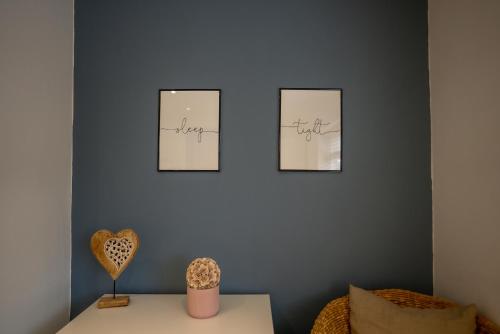 a room with three pictures on a wall with a table at Town Street Apartment in Marple