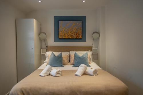 a bedroom with a bed with three pillows at Town Street Apartment in Marple