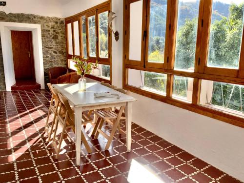 Zimmer mit einem Tisch und einigen Fenstern in der Unterkunft Finca Riolavar in Jubrique