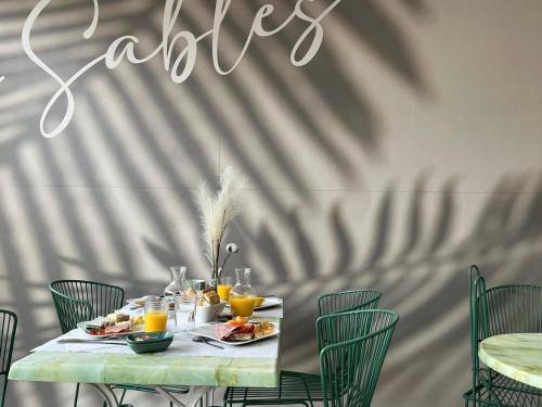 a table with food and orange juice on it at Hôtel Les Sables - Urban Style - by Logis Hotels in Canet-en-Roussillon