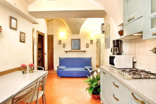 a kitchen with a blue couch in a room at Appartamento Stella in centro a Firenze in Florence