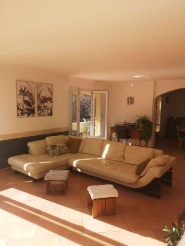 a living room with a large couch and tables at Chez TATA in Régusse