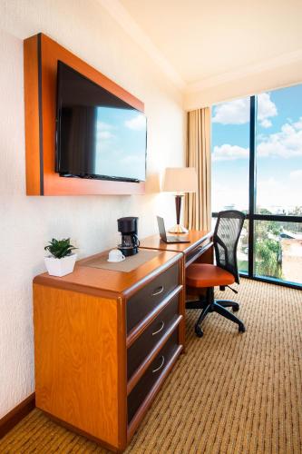 a hotel room with a desk and a large window at Hotel Guadalajara Plaza Expo in Guadalajara