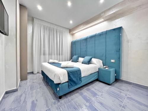 a blue bedroom with a large bed with a blue headboard at Hotel Paradiso in Lago Patria