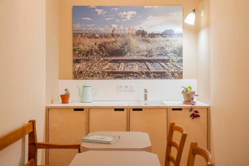 une cuisine avec une table et un tableau mural dans l'établissement Une chambre à l'Economat, à Bordeaux