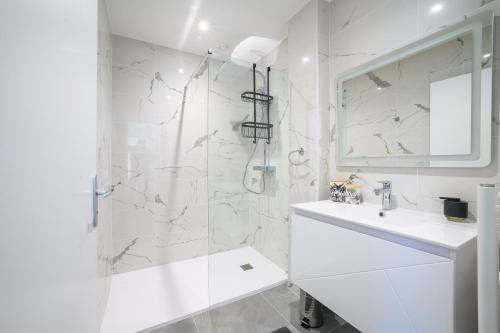 een witte badkamer met een douche en een wastafel bij Le Boudoir du Palais Climatisé & Luxueux in Périgueux