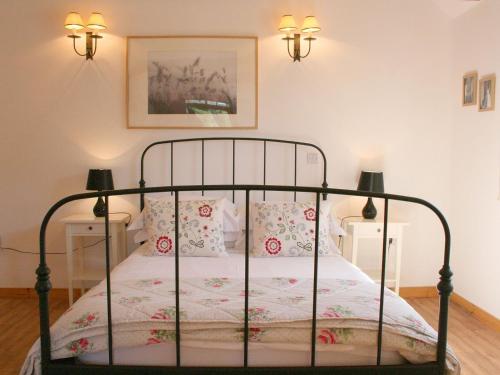 a bedroom with a metal bed with pillows at The Barn At Fishponds in Brook