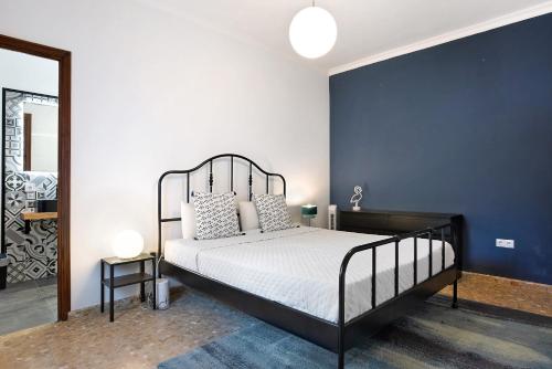 1 dormitorio con cama y pared azul en Villa Paraíso en Chiclana de la Frontera