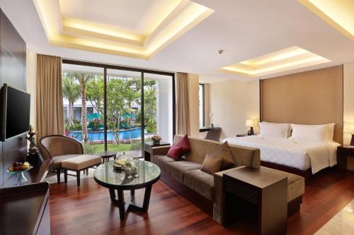 ein Hotelzimmer mit einem Bett und einem Sofa in der Unterkunft Bali Nusa Dua Hotel in Nusa Dua