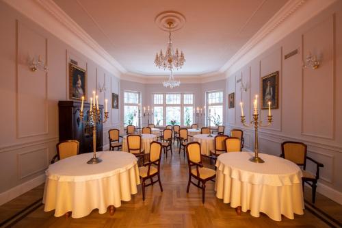 a room with tables and chairs and a chandelier at Willa Barbara - ProHarmonia in Lądek-Zdrój