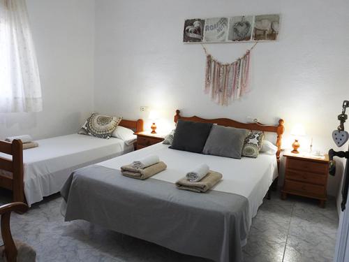 ein Schlafzimmer mit 2 Betten und Handtüchern darauf in der Unterkunft Casa rural Cal Gasso in El Poble Nou del Delta