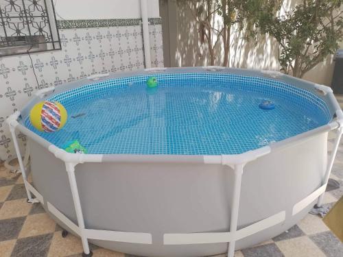 a large hot tub with a blue water in it at Dar chenini in Gabès