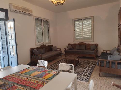 a living room with couches and a table at Dar chenini in Gabès