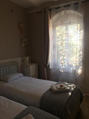 une chambre avec deux lits et une fenêtre dans l'établissement Appartement central des terres chaudes proche bord de mer, à Menton