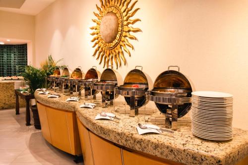 a buffet with wine glasses and plates on a counter at Hotel Guadalajara Plaza Expo in Guadalajara