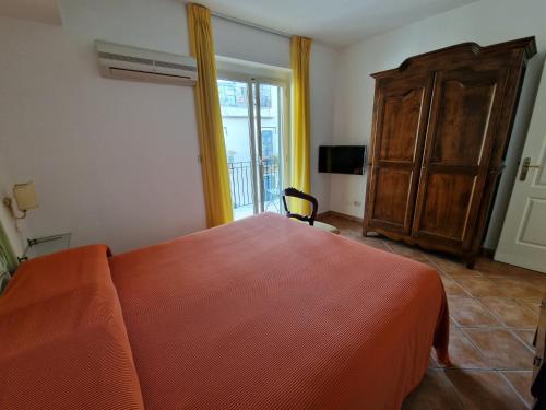 a bedroom with a bed and a dresser and a window at Residence Degli Agrumi in Taormina
