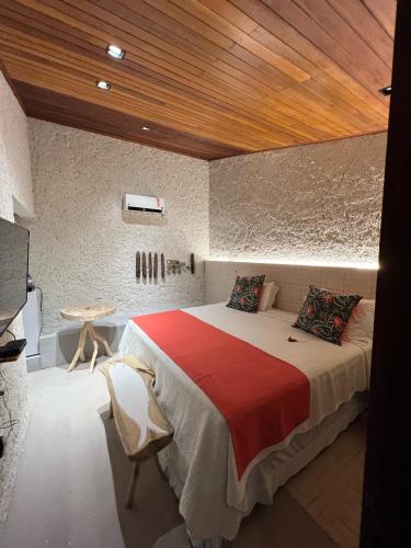 a bedroom with a large bed with a wooden ceiling at Villas Taturé in São Miguel dos Milagres