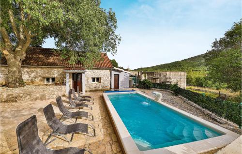 a swimming pool with chairs and a house at Beautiful Home In Prgomet in Labin