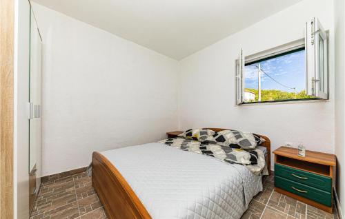 a small bedroom with a bed and a window at Beautiful Home In Prgomet in Labin