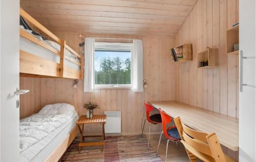 ÅlbækにあるBeautiful Home In lbk With 4 Bedrooms, Sauna And Wifiのベッド、デスク、二段ベッドが備わる小さな客室です。