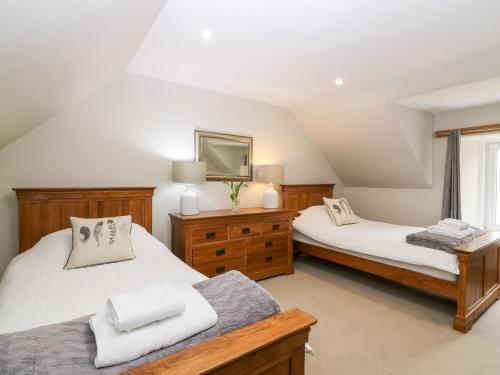 a bedroom with two beds and a window at White Hillocks Farm House in Inchmill