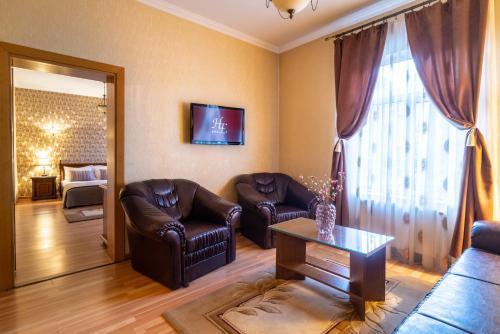 sala de estar con 2 sillas de cuero y mesa en Hotel Europa, en Târgu Jiu