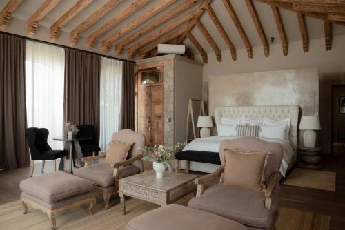 1 dormitorio con cama, sillas y mesa en Hotel Grand María en Morelia