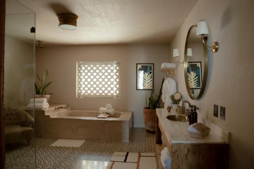 W łazience znajduje się wanna, umywalka i lustro. w obiekcie Hotel Grand María w mieście Morelia