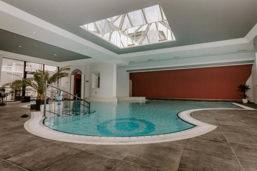 a swimming pool in a building with a skylight at FAIRien from home in Neusiedl am See