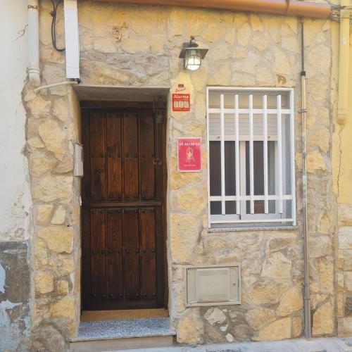 un edificio de piedra con una puerta de madera y una ventana en AM house en Burriana