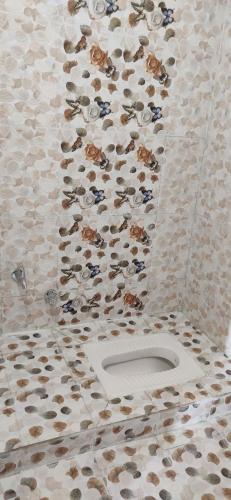 a bathroom with a toilet with a wall covered in animals at unTrained & unPlanned in Jabalpur