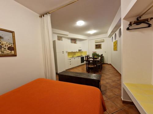 a bedroom with an orange bed and a kitchen at Residence Degli Agrumi in Taormina