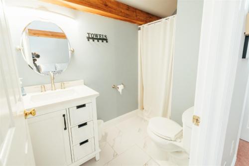 W łazience znajduje się umywalka, toaleta i lustro. w obiekcie Newly Renovated, Spacious Condo, 3 min to the ski lifts! w mieście Bethel