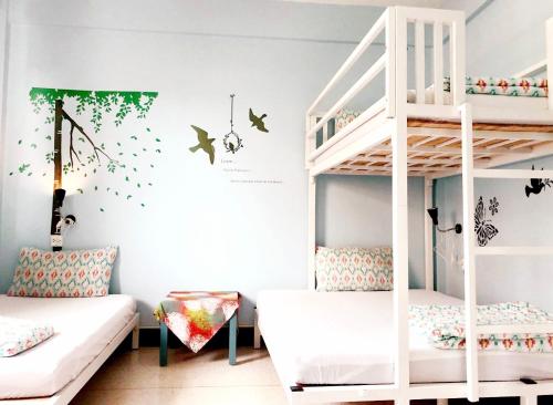 a childs room with a bunk bed and a ladder at Baan Nampetch Hostel in Bangkok