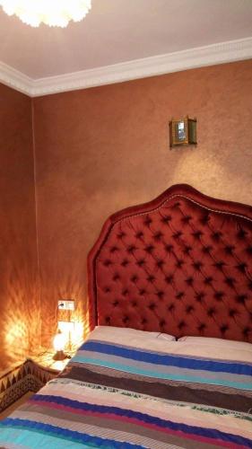a bedroom with a large bed with a red headboard at Riad Scalia Traditional Guesthouse Fes Morocco in Fès