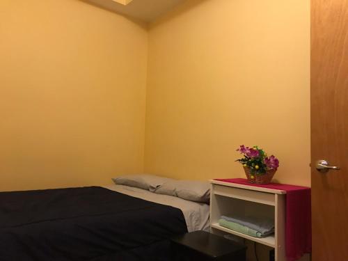 Un dormitorio con una cama y una mesa con flores. en Room 2 en Chicago