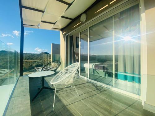 a balcony with two chairs and a table and a view at Hotel Carre Noir in Porto-Vecchio