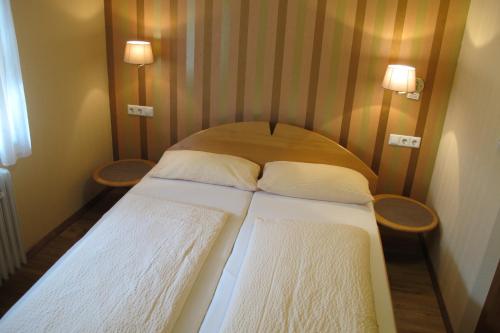 Cama en habitación pequeña con 2 almohadas en Landgasthof Schwabenpfanne, en Erbach