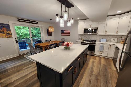 a kitchen with white cabinets and a kitchen island with flowers on it at Heart & Soul Hideaway in Harbor Springs